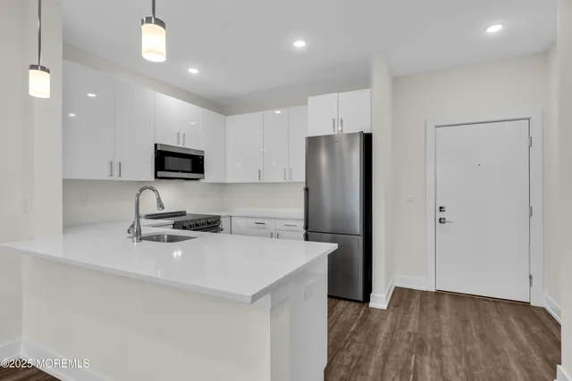 a kitchen with stainless steel appliances a refrigerator sink and microwave