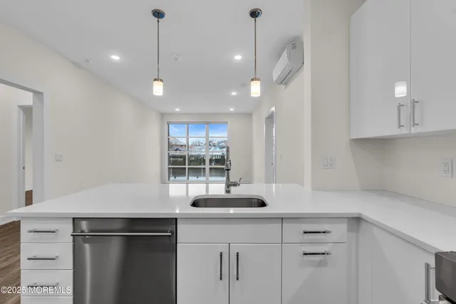 a kitchen with a refrigerator a stove and a sink with wooden floor