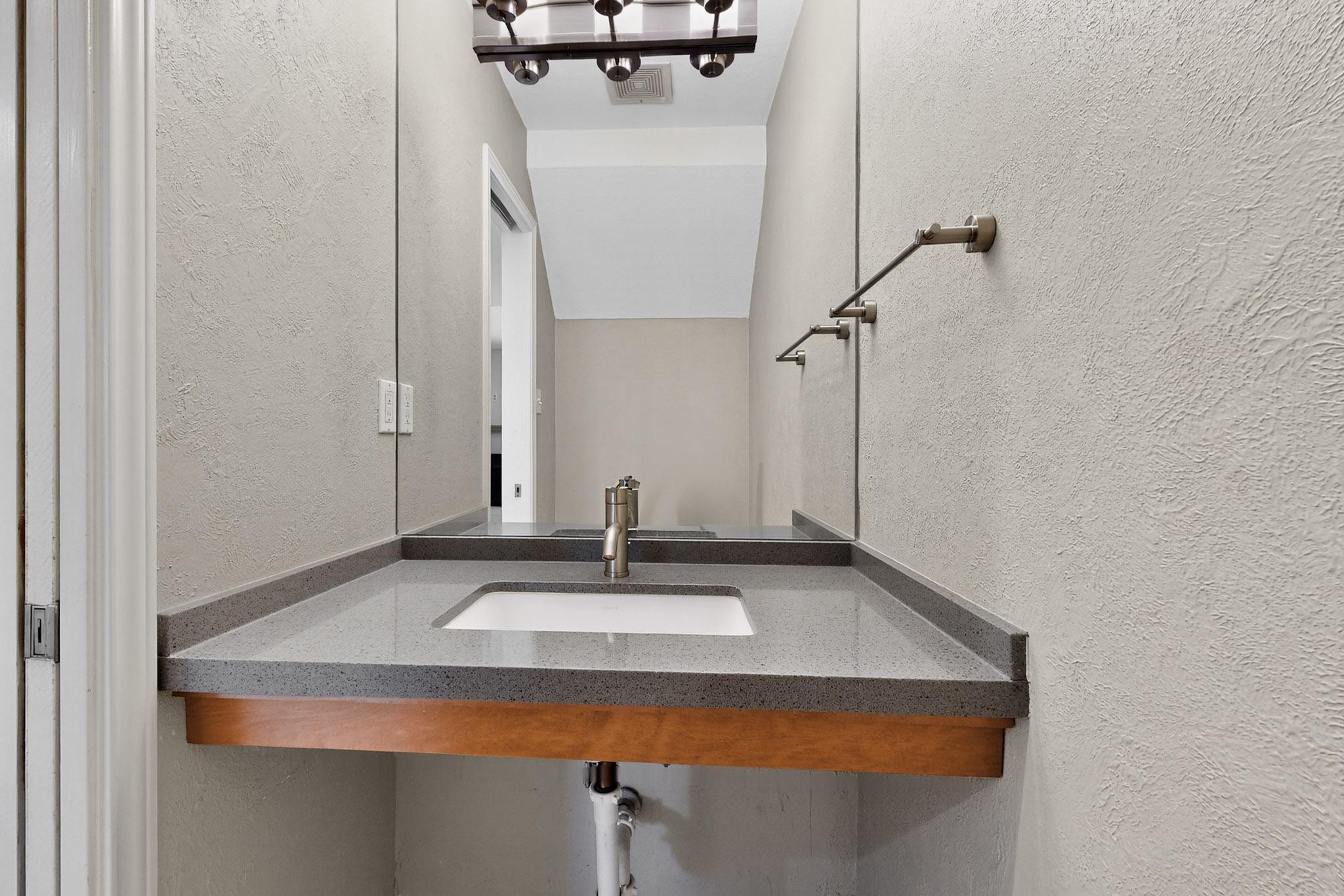 6023 Old Fredericksburg Road, Unit A Austin, TX 78749 - Photo 7 of 29 half bathroom with pocket door tucked under the stairs