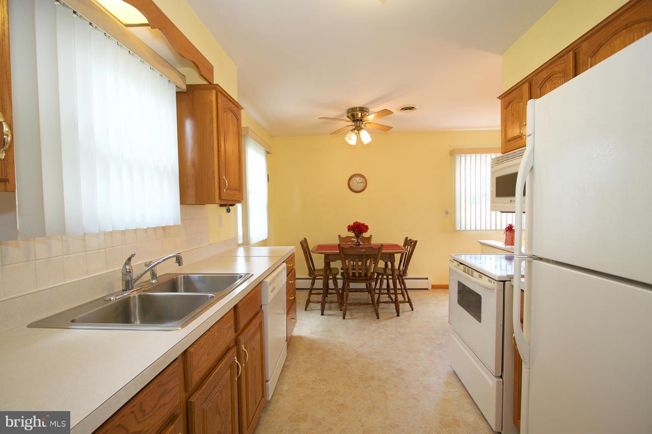 2307 Mills Road Fallston, MD 21047 - Photo 11 of 30 a kitchen with a sink cabinets and dining table chair