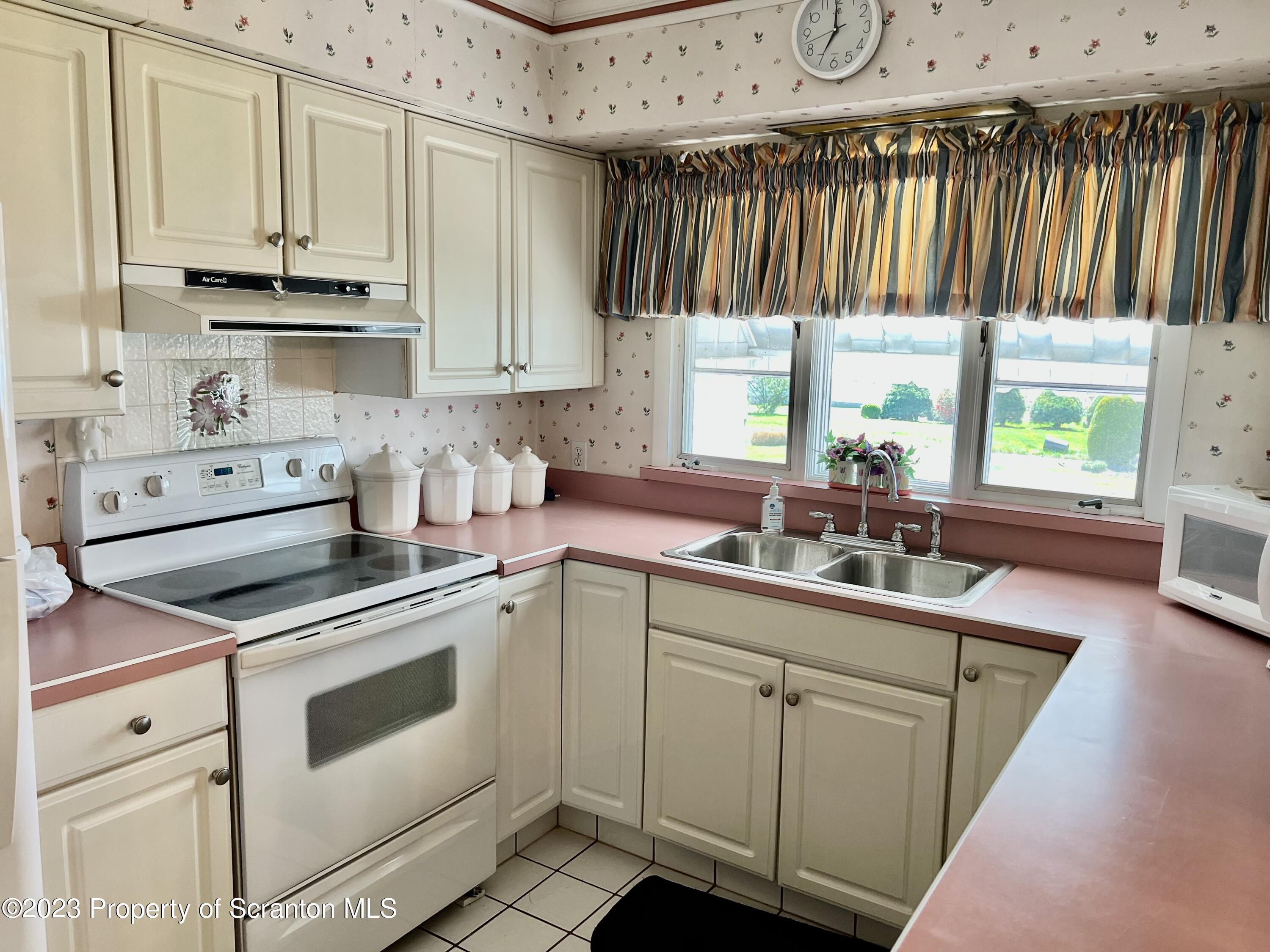 204 Moosic Road Old Forge, PA 18518 - Photo 12 of 31 a kitchen with cabinets appliances a sink and a window