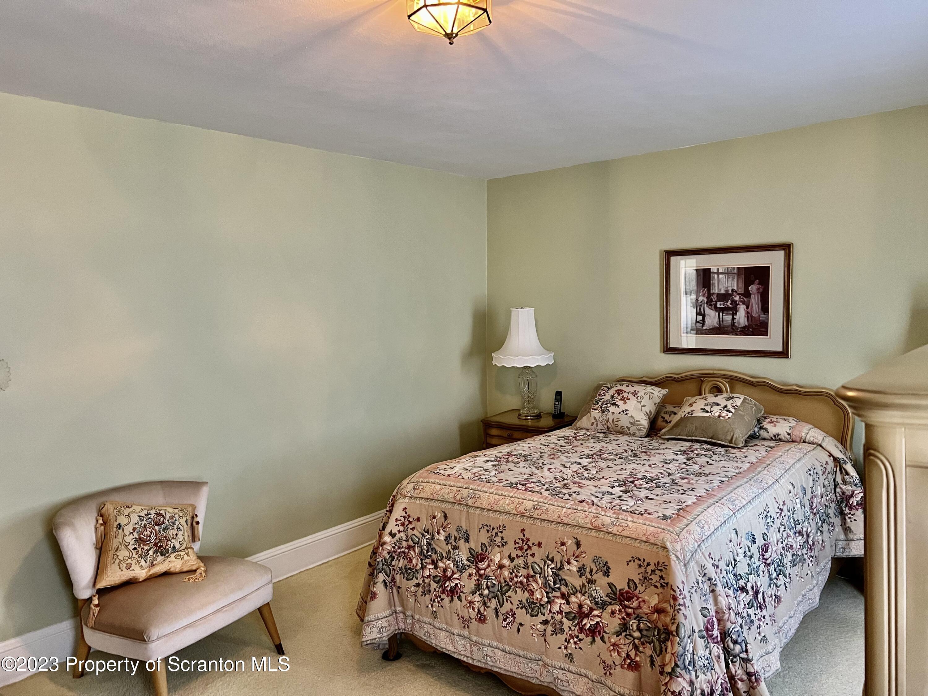 204 Moosic Road Old Forge, PA 18518 - Photo 22 of 31 a bedroom with a bed and chair