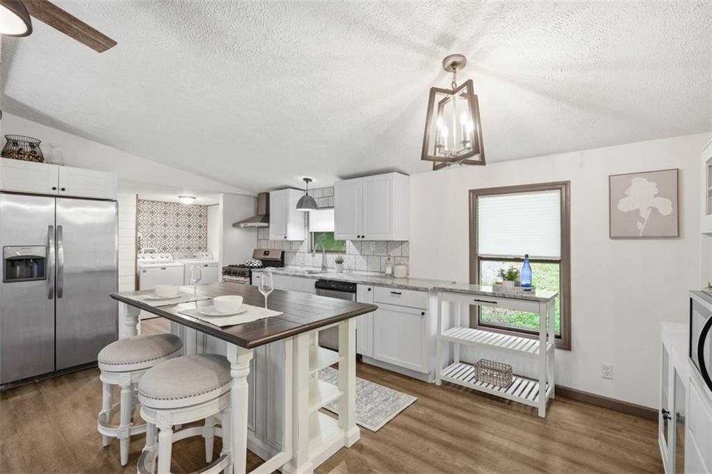 8517 Wittmer Road Pittsburgh, PA 15237 - Photo 3 of 46 a kitchen with stainless steel appliances a table chairs and a refrigerator