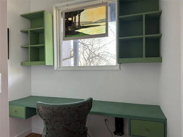 a view of a room that has a window and wooden floor