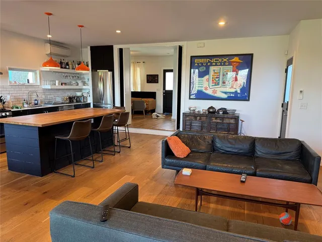 a living room with furniture kitchen view and a large window