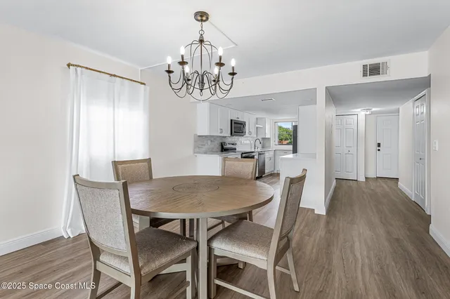 a view of a dining room with furniture wooden floor and chandelier