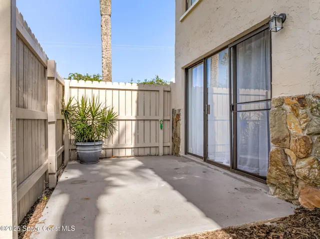 an empty room with windows and chandelier fan