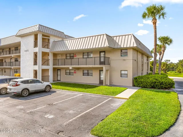 an aerial view of a house with a garden and lake view