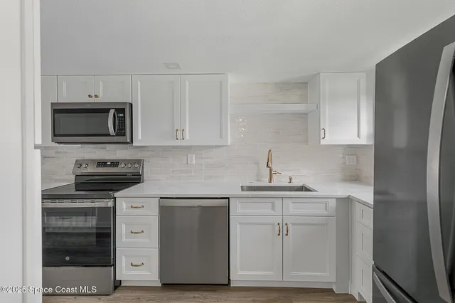 a kitchen with granite countertop a sink stove and cabinets