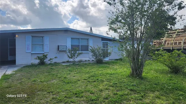 a backyard of a house with table and chairs