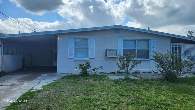 a backyard of a house with plants and barbeque oven