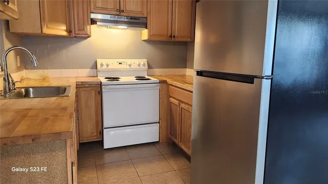 a kitchen with a refrigerator stove and sink