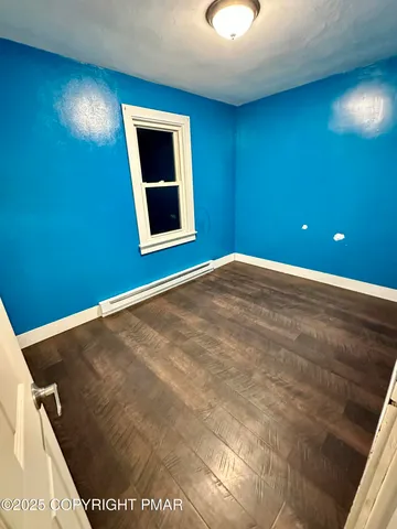 an empty room with wooden floor and sliding door