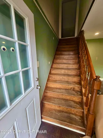 a view of a livingroom with a fireplace a window and wooden floor