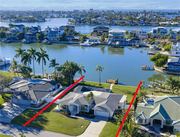 a front view of a house with a garden and palm trees