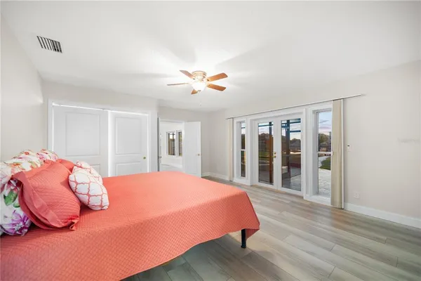 a spacious bedroom with a bed and a chandelier