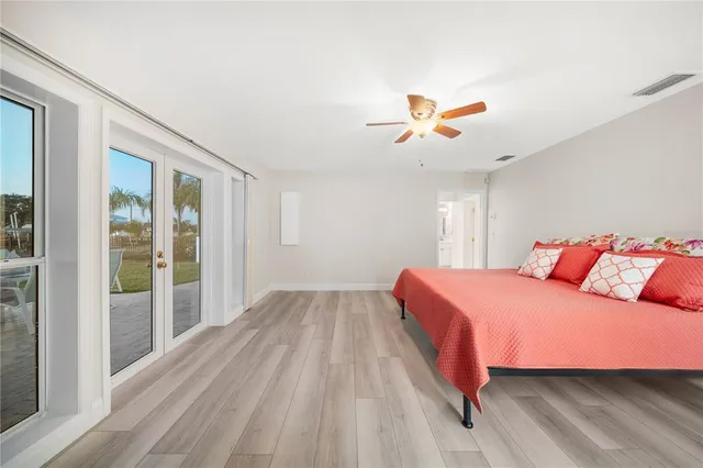 a spacious bedroom with a bed and a chandelier