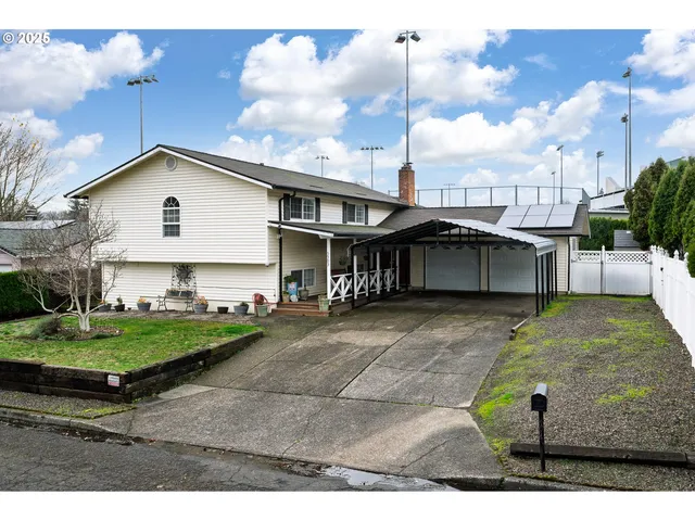a view of a big house with a big yard and large trees