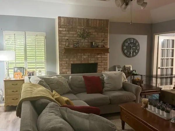 a living room with furniture a fireplace and a chandelier