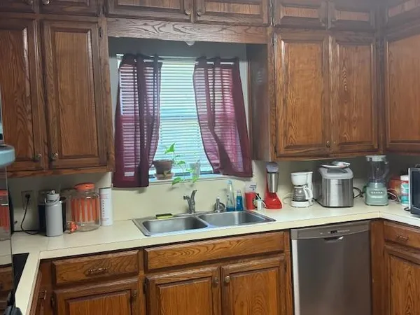 a kitchen with stainless steel appliances granite countertop a sink a stove and cabinets
