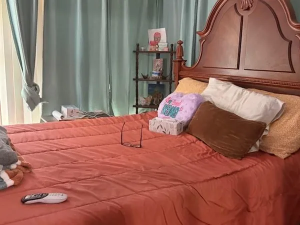 a bed sitting in a bedroom next to a window