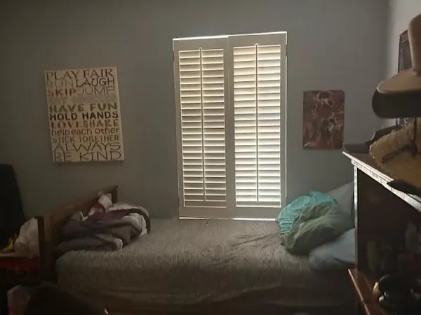 a bed sitting in a bedroom next to a window