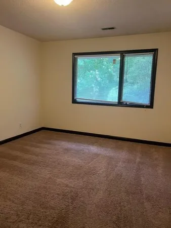 a view of a big room with wooden floor and windows