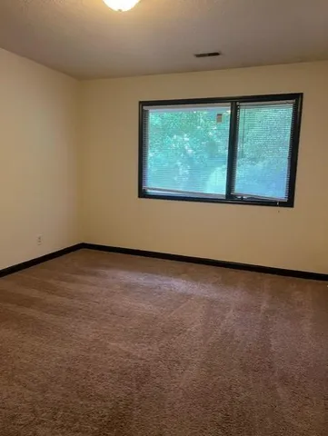 a view of a big room with wooden floor and windows