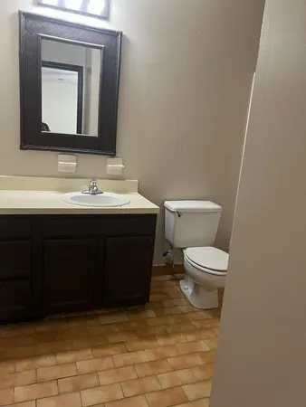 a bathroom with a toilet sink and mirror