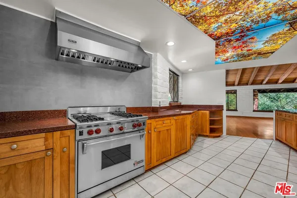 a large kitchen with stainless steel appliances granite countertop a stove and a sink