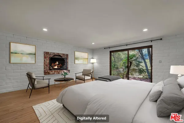 an empty room with wooden floor and a fireplace