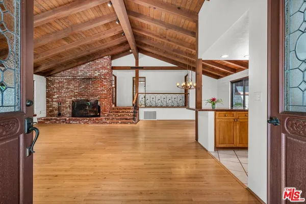a view of empty room with wooden floor and fireplace