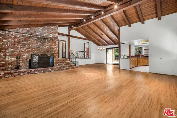 a view of empty room with wooden floor and fireplace