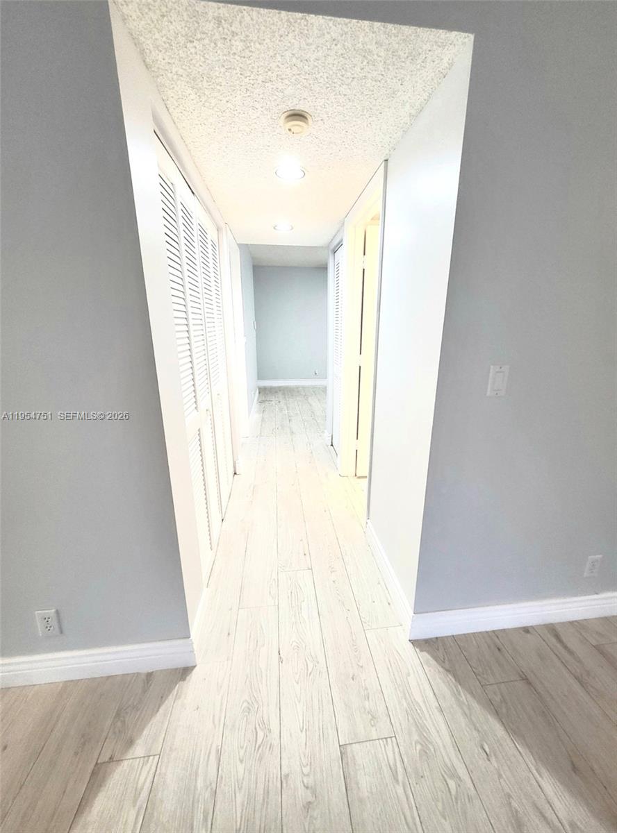 17286 Boca Club Boulevard, Unit 2108 Boca Raton, FL 33487 - Photo 20 of 25 a view of a hallway with wooden floor and staircase