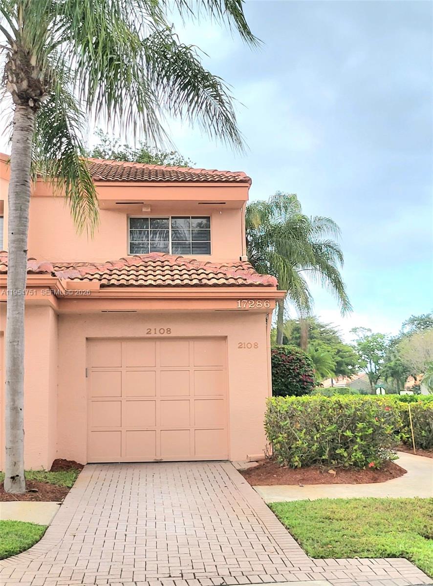 17286 Boca Club Boulevard, Unit 2108 Boca Raton, FL 33487 - Photo 2 of 25 a view of a house with a yard and palm trees