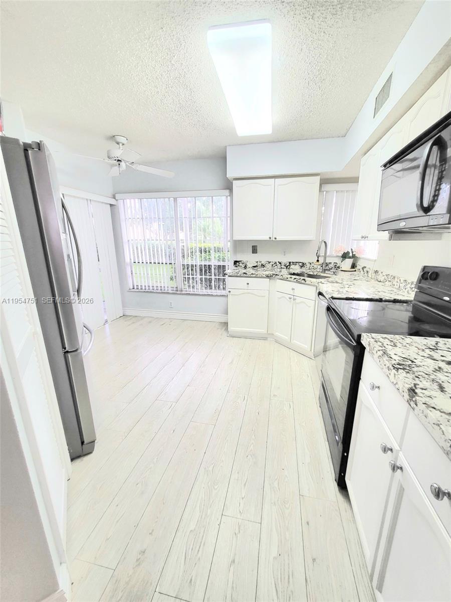 17286 Boca Club Boulevard, Unit 2108 Boca Raton, FL 33487 - Photo 8 of 25 a kitchen with stainless steel appliances a stove a sink a refrigerator a cabinets and wooden floor