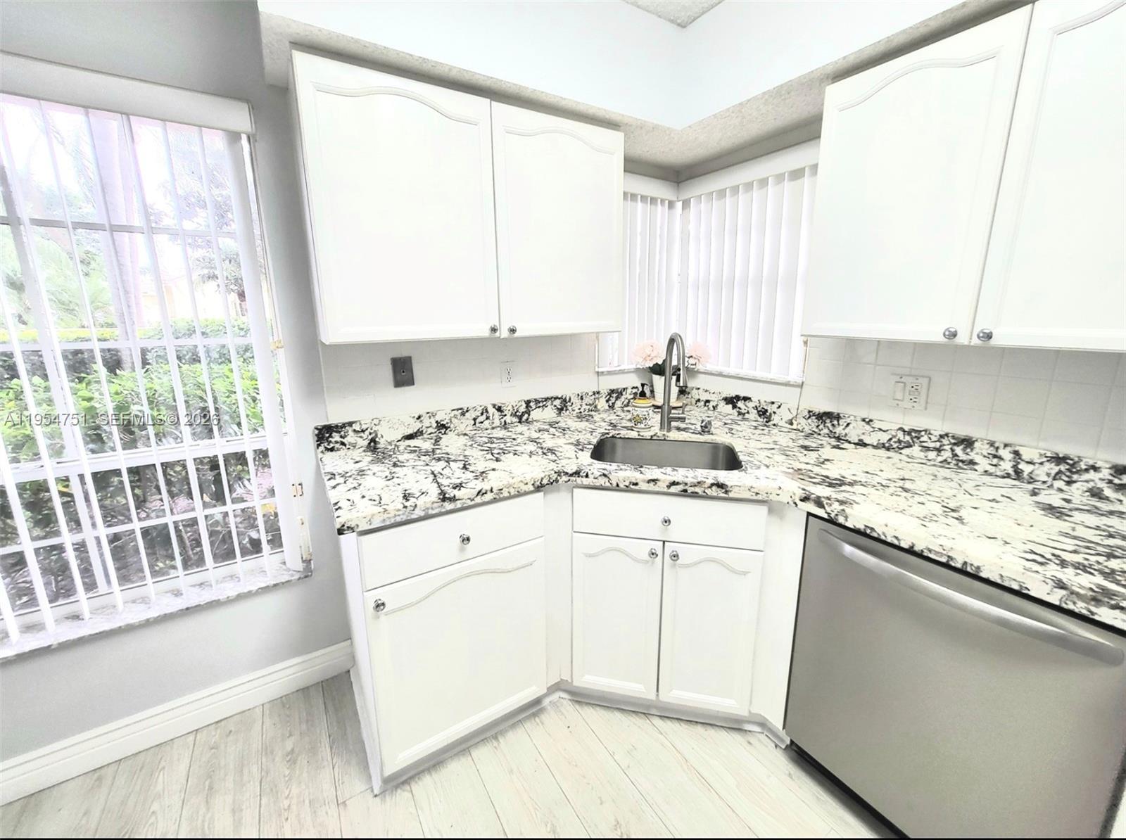 17286 Boca Club Boulevard, Unit 2108 Boca Raton, FL 33487 - Photo 9 of 25 a kitchen with granite countertop white cabinets and white appliances