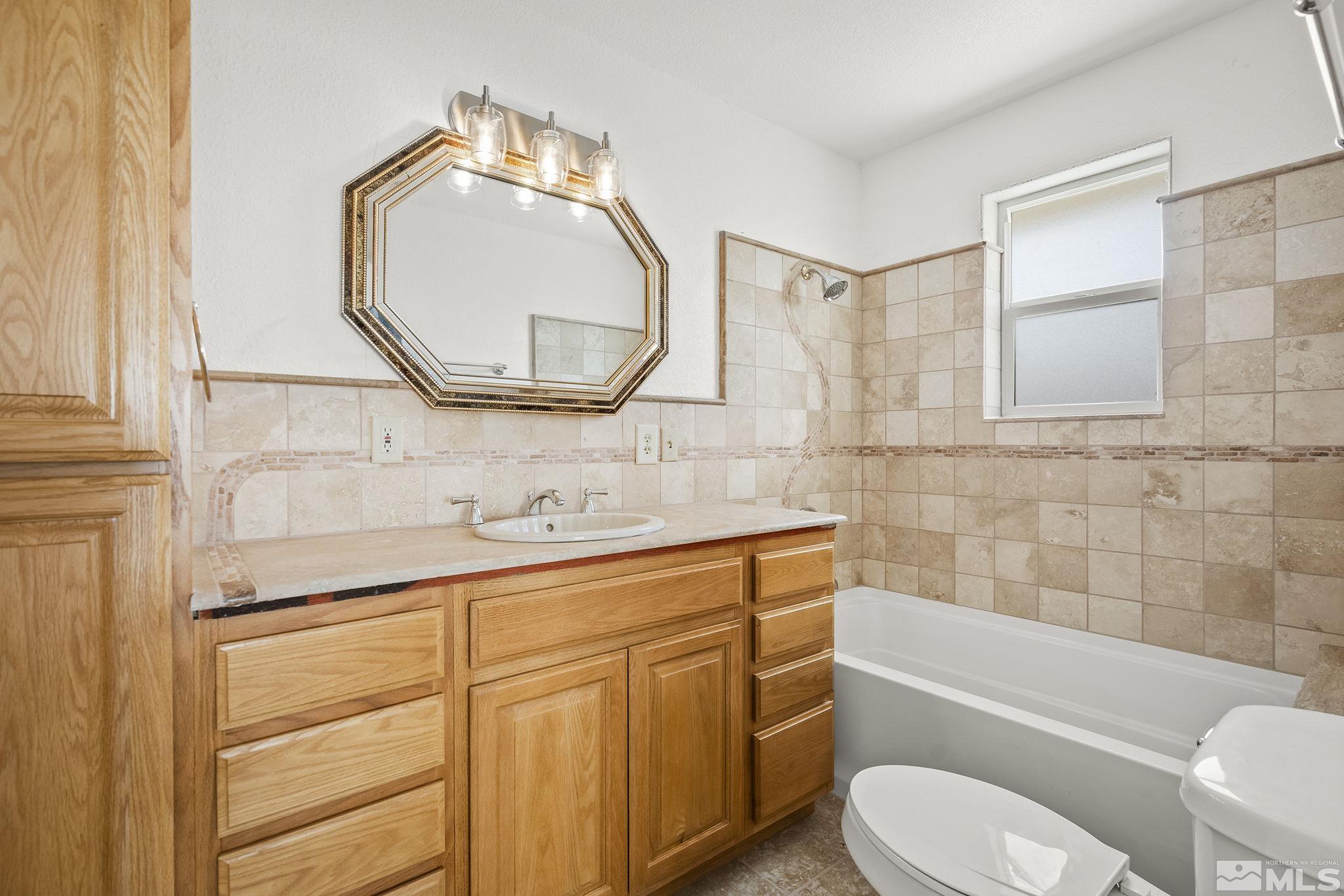 3300 Alcorn Road Fallon, NV 89406 - Photo 15 of 40 a bathroom with a toilet sink vanity tub and mirror