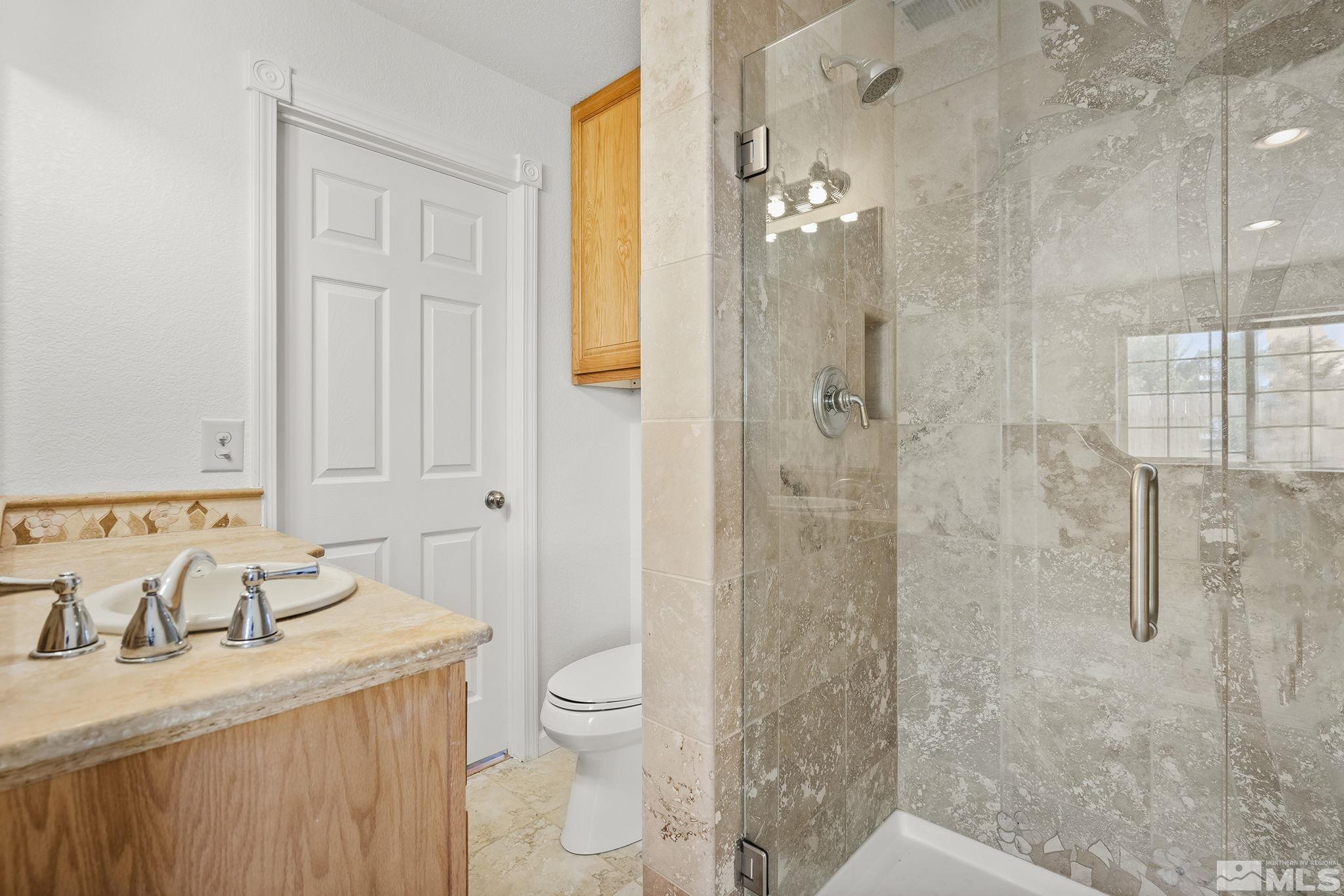 3300 Alcorn Road Fallon, NV 89406 - Photo 17 of 40 a bathroom with a granite countertop sink a toilet and shower