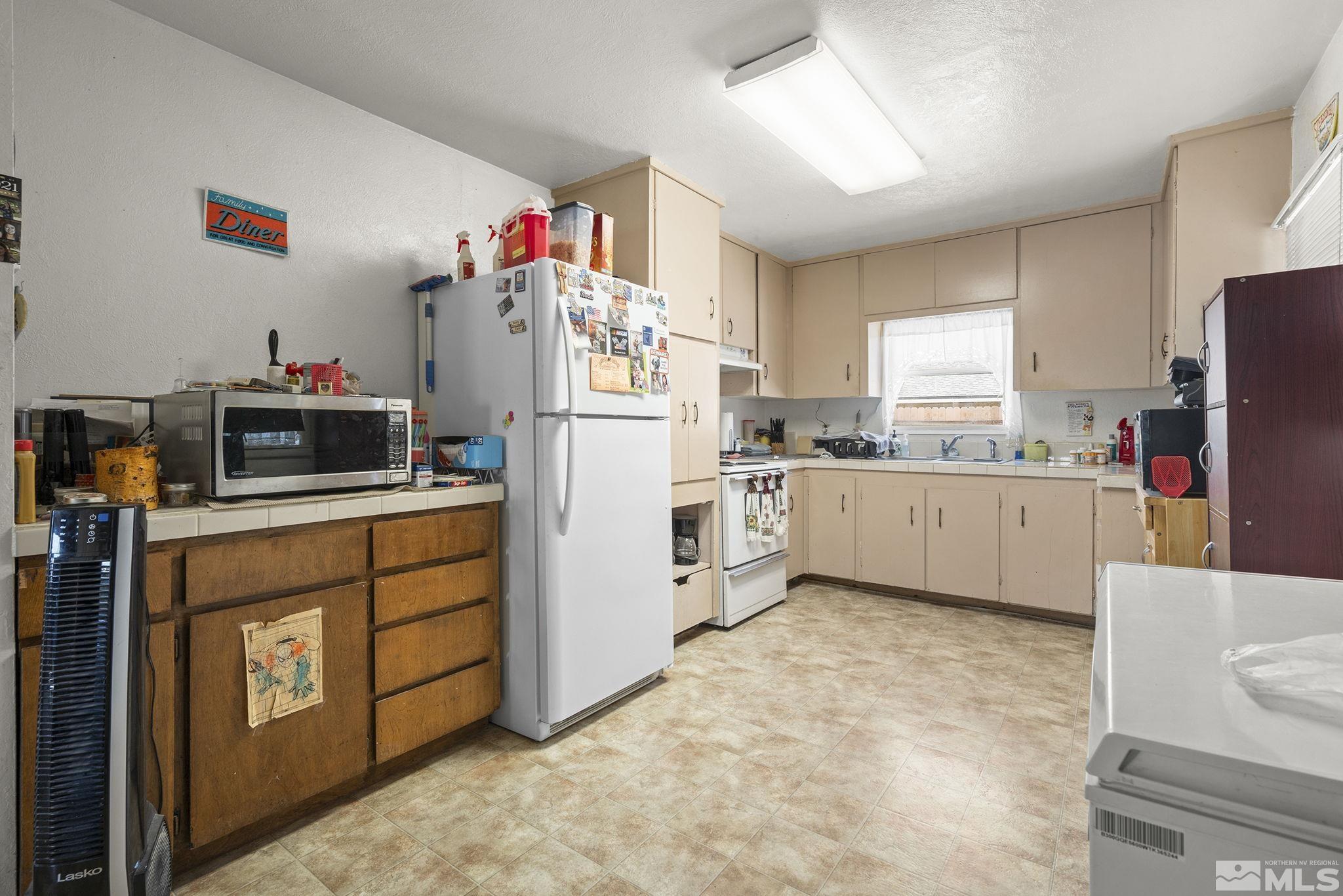 3300 Alcorn Road Fallon, NV 89406 - Photo 40 of 40 a kitchen with white cabinets and white appliances