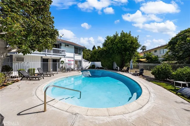 a view of a swimming pool with a patio and fire pit