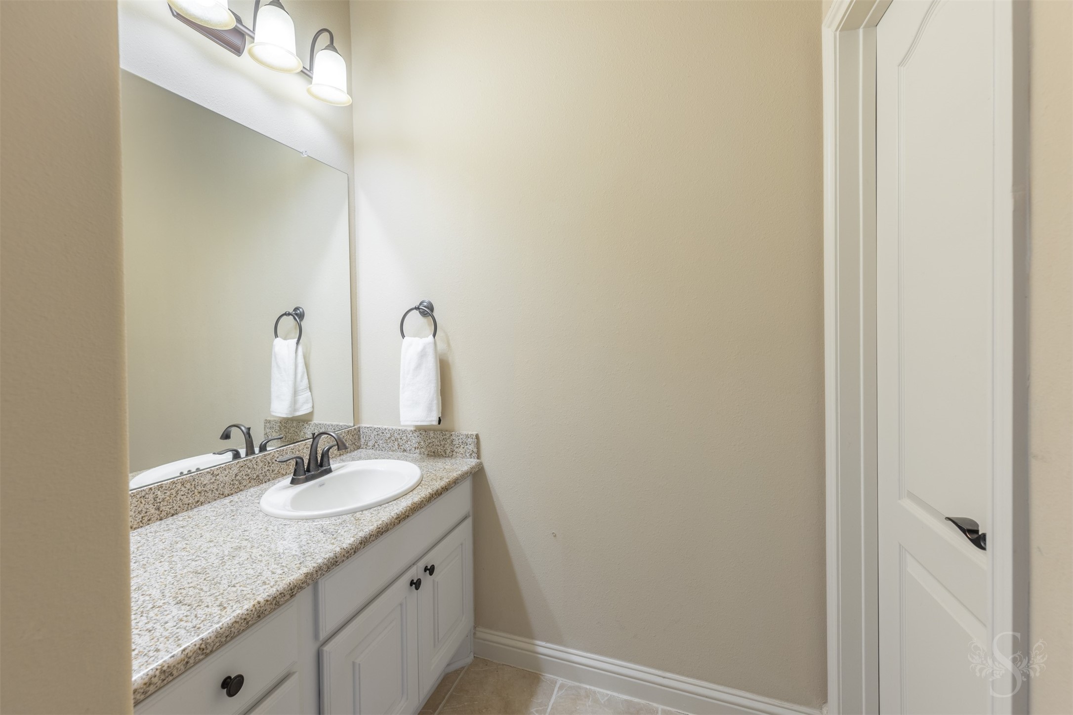 5803 Mustang Ridge Lane Fulshear, TX 77441 - Photo 32 of 48 Vanity area features granite countertops, ample cabinet storage and updated lighting with direct access to the full bath. Designed with convenience in mind, the layout offers added privacy and functionality for the secondary bedroom suite.