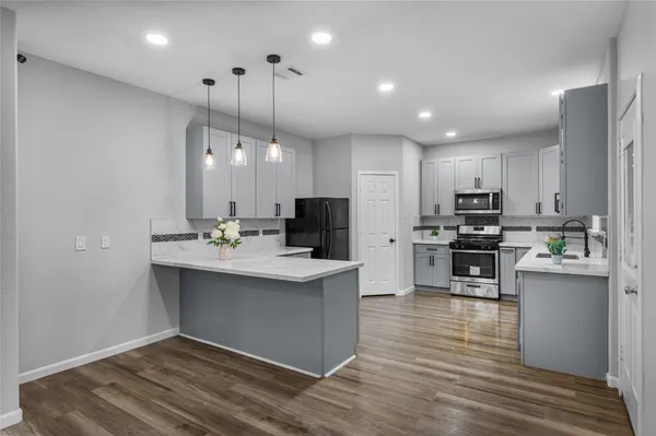 a kitchen with kitchen island a sink stainless steel appliances and cabinets