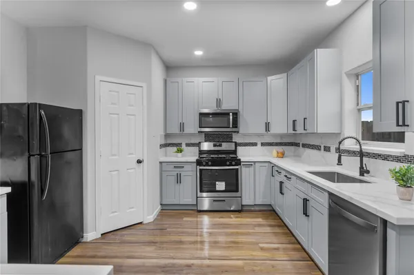 a large kitchen with a stove top oven a refrigerator and a sink