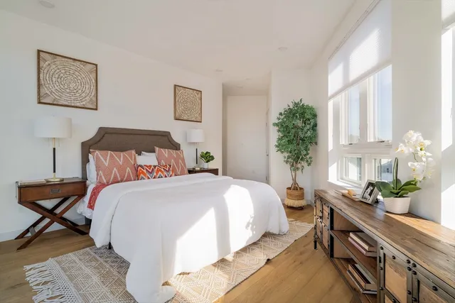 a bedroom with bed and a potted plant