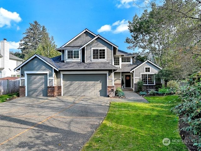 a front view of a house with yard and green space
