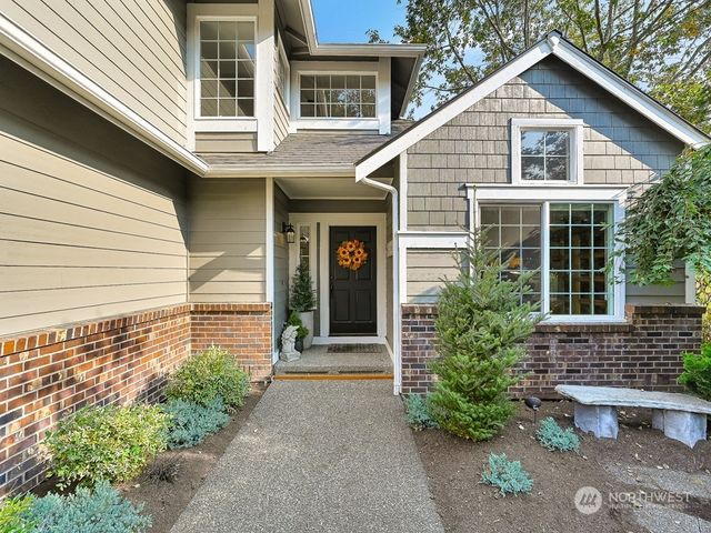 a view of a house with a yard and potted plants