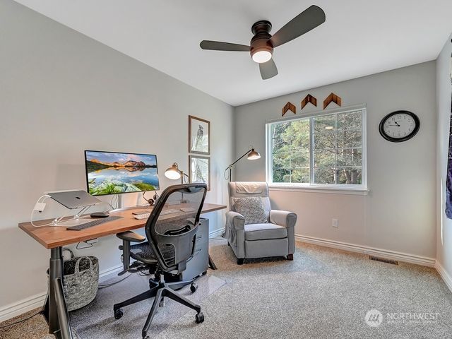 a view of a workspace with furniture and a window