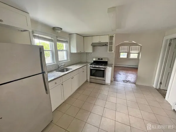 a kitchen with stainless steel appliances granite countertop a refrigerator sink and stove