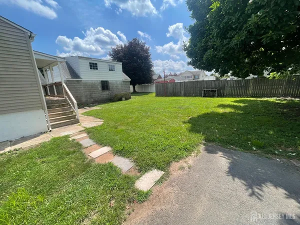 a view of backyard with barbeque grill potted plants and large tree